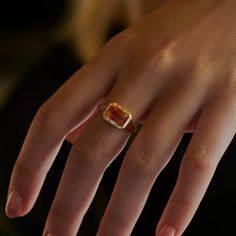 a woman's hand with a yellow and red ring on top of her finger