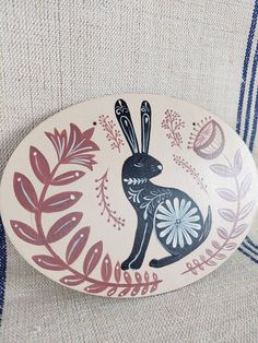 a decorative wooden plate with a rabbit on it