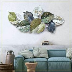 a living room with a blue couch and large metal leaf wall art on the wall