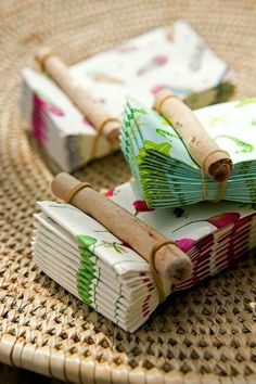 two small books are sitting on a wicker plate with twine spools