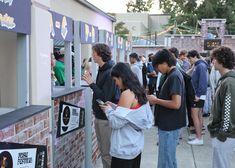 a group of people standing next to each other near a vending machine