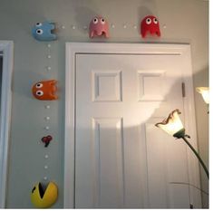 the door is white and has three little monsters on it's knobs hanging from the wall