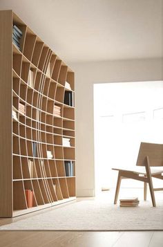 a wooden chair sitting in front of a book shelf