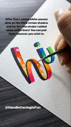 someone is painting the letter m with watercolors on paper and using a marker