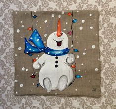 a painting of a snowman with a blue hat and scarf on it's head