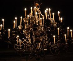 a chandelier with many lit candles in the dark