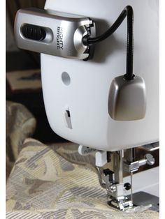 the sewing machine is being used to sew something on it's armrests