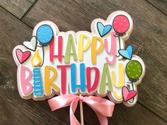 a happy birthday card with balloons on it and a pink ribbon tied to the front