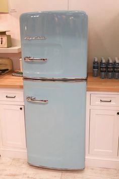 an old fashioned blue refrigerator in a kitchen