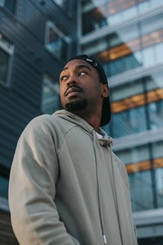 a man standing in front of a building looking up at the sky with his eyes closed