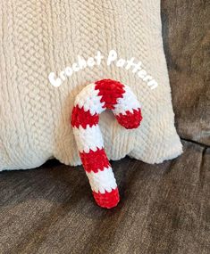 a red and white candy cane sitting on top of a pillow