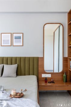 a bedroom with a bed, dresser and mirror in it's corner next to a book shelf