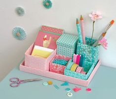 an assortment of stationery items displayed in a pink and blue holder on a table