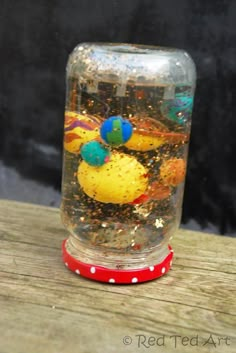 a glass jar filled with different colored birds