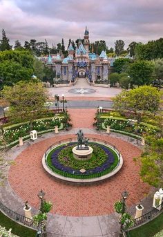 an aerial view of a garden with a statue in the center