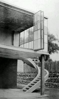 an old black and white photo of a building with stairs leading up to the roof