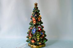 a small christmas tree with lights on it's sides and a string attached to the base