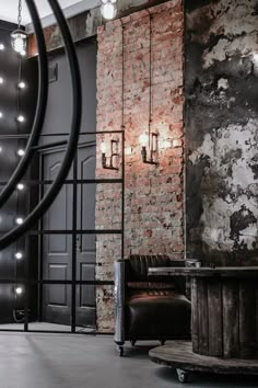 an industrial style living room with exposed brick walls and lights hanging from the ceiling, along with a leather chair