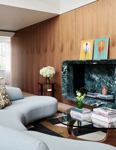 a living room filled with furniture next to a wooden wall