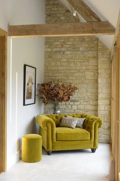 a living room filled with furniture next to a brick wall