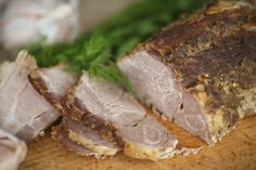 sliced ham sitting on top of a wooden cutting board