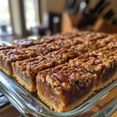 a glass dish filled with pecan bars on top of a stovetop oven burner