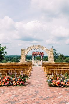 an outdoor ceremony setup with wooden chairs and flowers