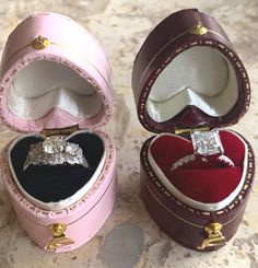 two pink and white boxes with wedding rings inside