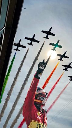 an image of a man that is in the air with his arms up and some planes flying behind him