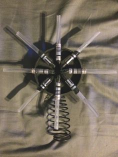 a clock made out of four forks and springs on top of a sheeted surface