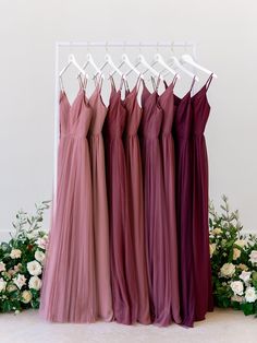 four bridesmaid dresses hanging on a rack