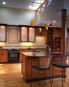 a kitchen with wooden cabinets and an island in the center, surrounded by two bar stools