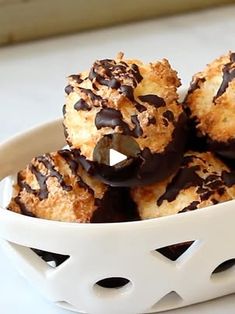 a white bowl filled with chocolate covered donuts