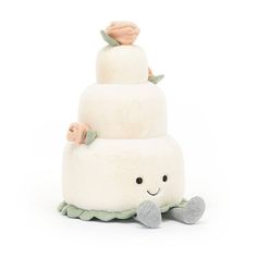 a three tiered cake sitting on top of a white floor next to a stuffed animal