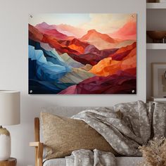 a living room scene with focus on the couch and wall hanging above it is an abstract painting