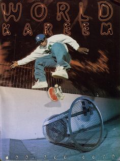 a man riding a skateboard up the side of a metal fence next to a trash can