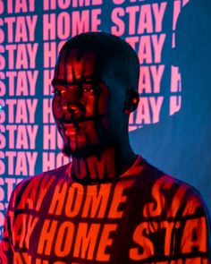 a man standing in front of a wall with words all over his body and face