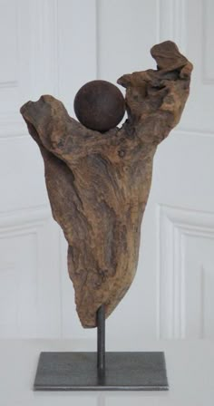 a piece of wood with a ball on it sitting on top of a metal stand