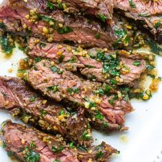 grilled steak with chimica sauce and herbs on a white serving platter