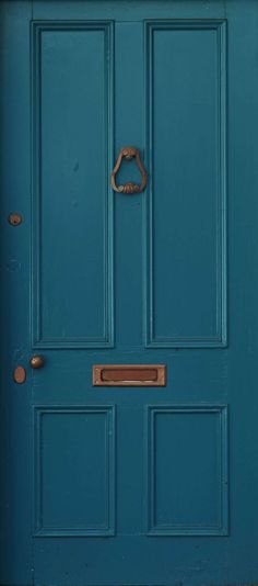 a blue door with a metal handle on it's side and the bottom panel is painted teal