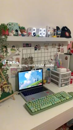 a laptop computer sitting on top of a white desk next to a keyboard and mouse