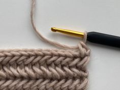 a crochet stitch with a golden needle