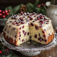 a cake with white frosting and cranberry toppings is on a plate