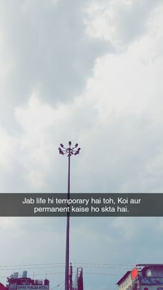 a tall light pole sitting under a cloudy blue sky with the words jab life in temporary hat, koi aur permanent