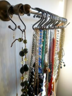 there is a rack with many different necklaces hanging from it's hooks and the caption reads, use shower hooks to hold necklaces