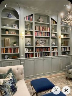 a living room filled with lots of bookshelves next to a couch and chair