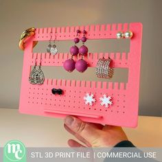 a person holding up a pink board with jewelry on it and the words stl 3d file commercial use