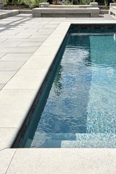 an empty swimming pool with steps leading up to it and a fire hydrant in the background