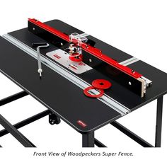 an image of a table sawing machine on top of a black table with red wheels