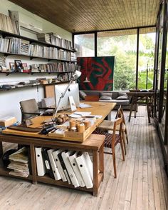 a room filled with lots of furniture and bookshelves next to a wooden floor